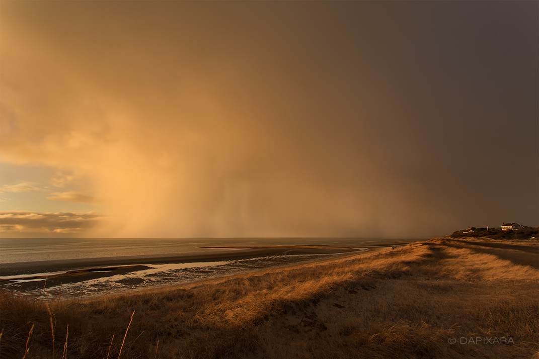 Giant snow cloud touching the Cape Cod bay on Eastham, First Encounter beach. Winter weather photograph Dapixara.
